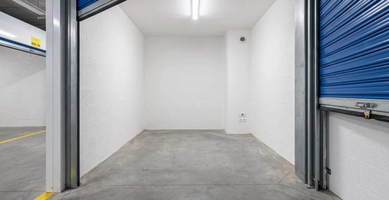 Intérieur d'un box de stockage vide montrant les murs propres et l'éclairage LED au plafond
